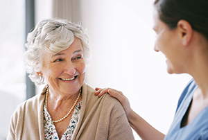 happy senior woman being cared for by a nurse